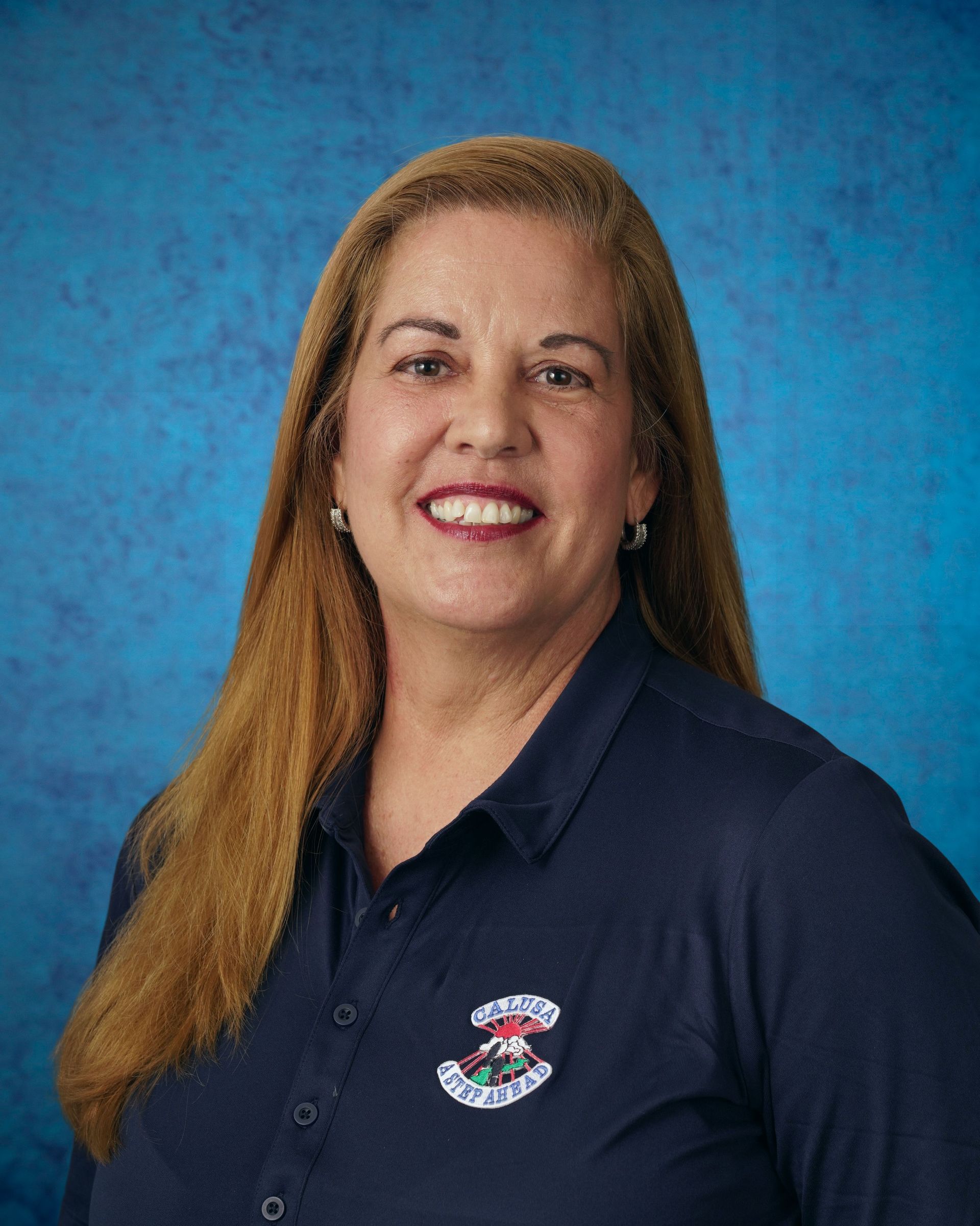 Portrait of Principal Suzet Hernandez wearing a navy Calusa polo